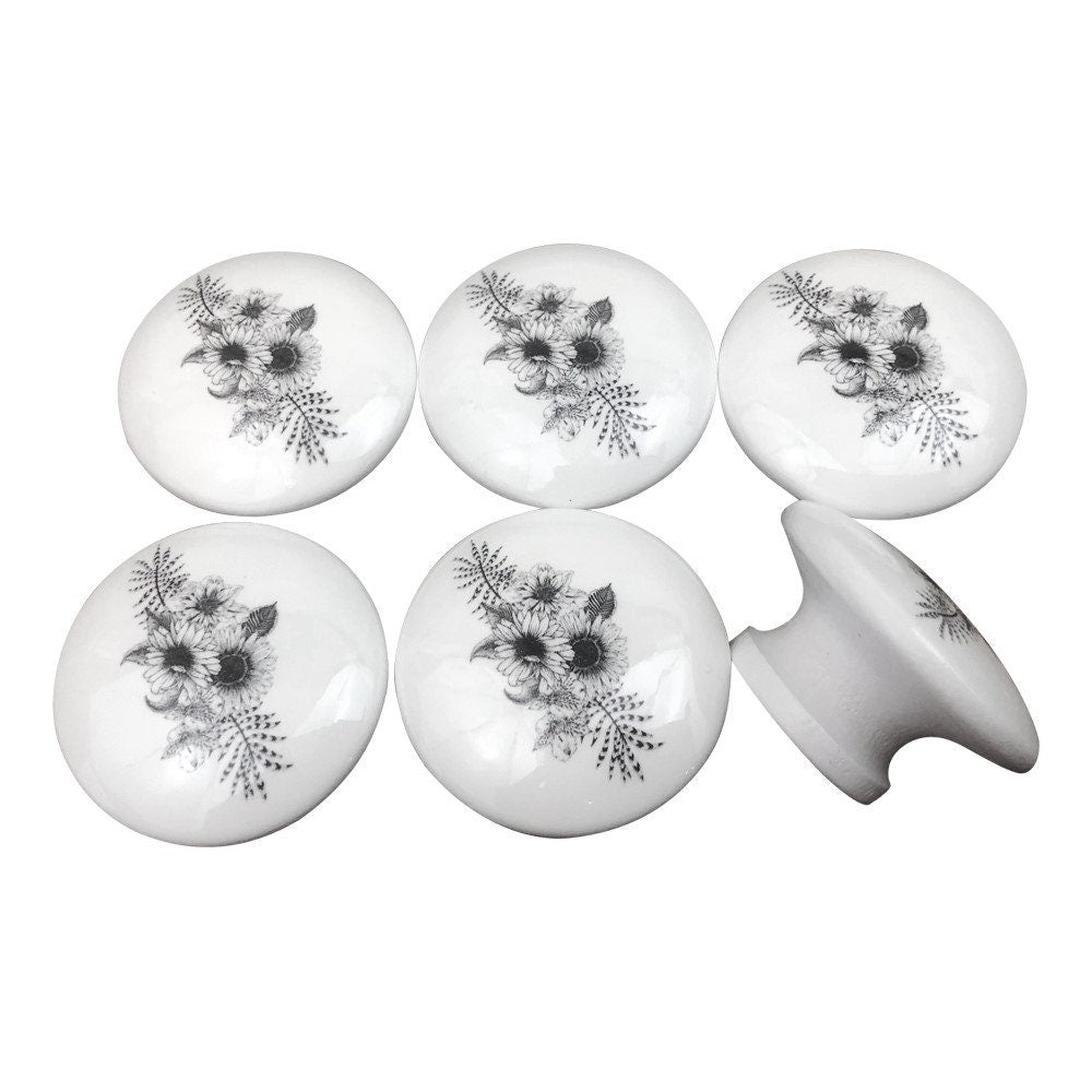 Juego de 6 pomos de madera con diseño floral en blanco y negro.